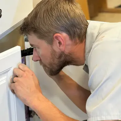 pest control technician inspecting kitchen